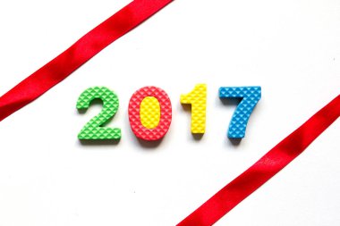 Beyaz zemin üzerine kırmızı kurdele ile oyuncak alfabesinden 2017 ifadeler
