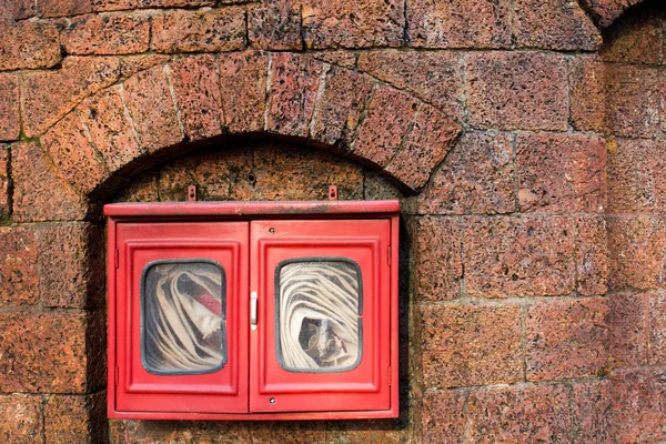 Tuyau d'incendie en boîte rouge sur fond de mur de briques — Photo