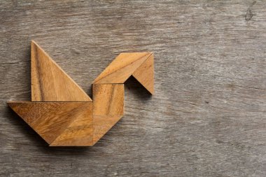 Eski ahşap arka plan üzerinde kuş şekli olarak ahşap tangram