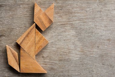 Şekil eski ahşap arka plan üzerinde oturan kedi olarak ahşap tangram