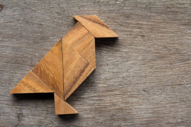 Eski ahşap arka plan üzerinde kuş şekli olarak ahşap tangram