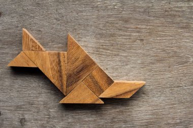 Eski ahşap arka plan üzerinde balık şekil (balık) olarak ahşap tangram