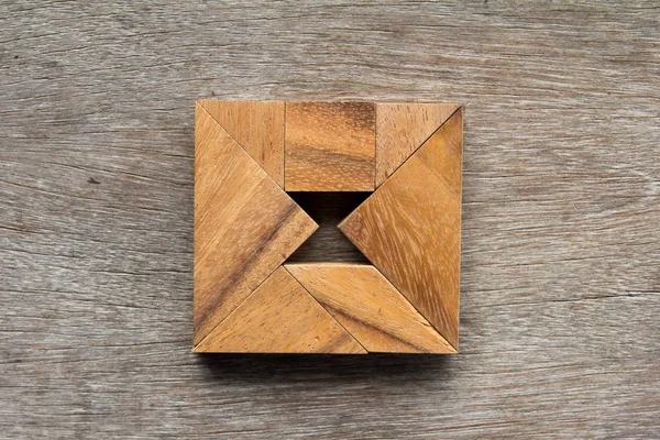 Dřevěný tangram jako čtverec s přesýpací hodiny uvnitř obrazce na staré dřevo — Stock fotografie