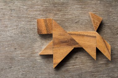 Eski ahşap arka plan üzerinde çalışan köpek şekil olarak ahşap tangram