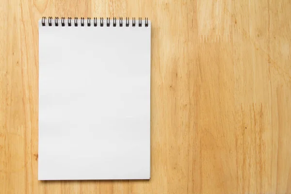 Blanco papier notitie boek over houten tafel achtergrond — Stockfoto