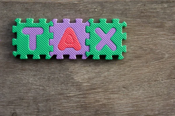 Hračky abeceda formulace daň z dřevěné pozadí — Stock fotografie