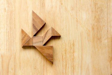 Ahşap arka plan (Concep üzerinde kuş şekli uçan bulmaca Tangram