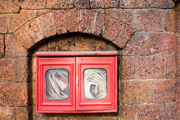 Tuyau d'incendie en boîte rouge sur fond de mur de briques — Photo