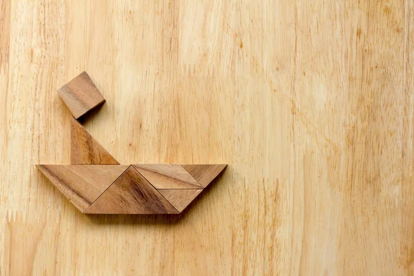 Tangram puzzle v člověka na lodi tvaru na dřevěné pozadí — Stock fotografie