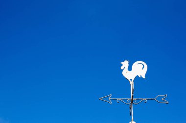 Beyaz horoz weather vane Haritayı mavi gökyüzü arka plan üzerinde rüzgar yönü