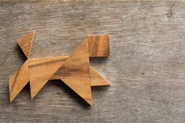 Eski ahşap arka plan üzerinde çalışan köpek şekil olarak ahşap tangram