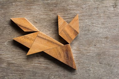 Eski ahşap arka plan üzerinde çalışan kedi şekil olarak ahşap tangram