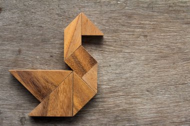 Eski ahşap arka plan üzerinde kuş şekli olarak ahşap tangram