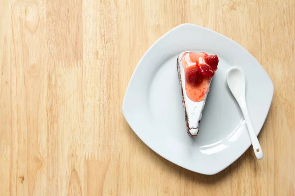 Φράουλα τούρτα με λευκή πλάκα σε φόντο ξύλινη — Φωτογραφία Αρχείου