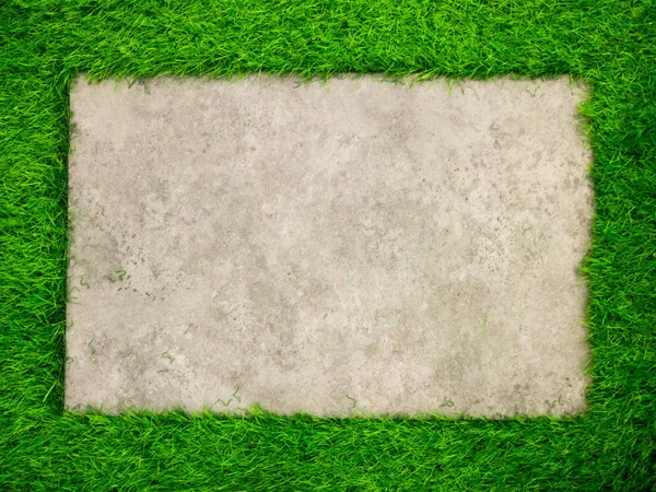 Placa de concreto quadrado no fundo de grama verde artificial — Fotografia de Stock