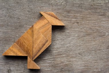 Eski ahşap arka plan üzerinde kuş şekli olarak ahşap tangram