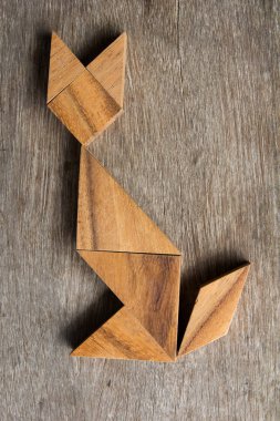Şekil eski ahşap arka plan üzerinde oturan kedi olarak ahşap tangram