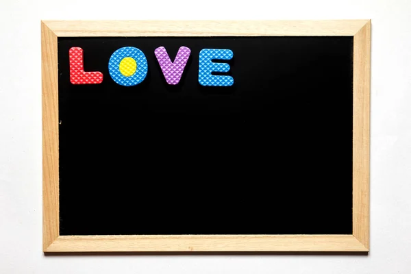 Schwarze Tafel mit der Aufschrift Liebe auf weißem Hintergrund — Stockfoto