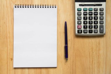 Boş kağıt not defteri kalem, ahşap masa hesap makinesi ile