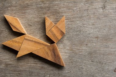 Eski ahşap arka plan üzerinde çalışan kedi şekil olarak ahşap tangram