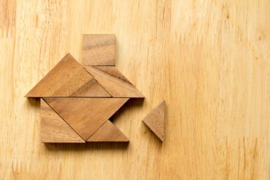 Ahşap arka plan (rüya ev kavramı üzerinde eksik parça ile ev şeklinde bulmaca Tangram)