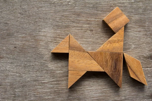 Dřevěný tangram jako člověk jezdit koně tvar na staré dřevo poza — Stock fotografie