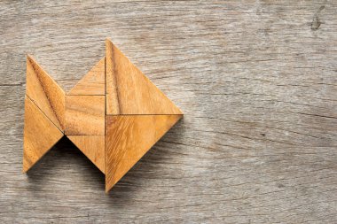 Ahşap arka plan üzerinde balık şeklinde bulmaca Çince tangram