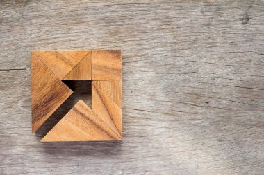 Tangram bulmacanın ahşap arka plan (Cooncept iş yönetmeni ve karar üzerinde kare şeklinde ok gibi)
