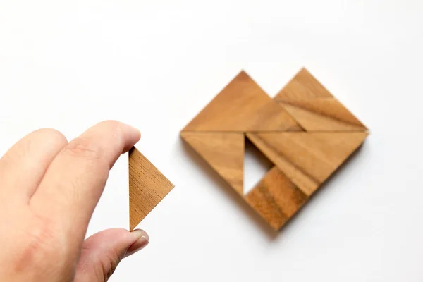 Hombre sostuvo pieza de rompecabezas tangram para cumplir con la forma del corazón en w —  Fotos de Stock
