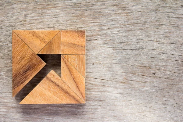 Tangram puzzle-nyíl a négyzet alakú fa háttér (koncepció, üzleti irányát és a határozat) — Stock Fotó