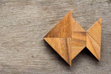 Ahşap arka plan üzerinde balık şeklinde bulmaca Çince tangram