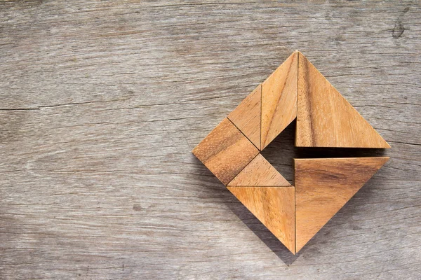 Rompecabezas Tangram como flecha en forma cuadrada sobre fondo de madera (Concepto para la dirección del negocio y la decisión ) —  Fotos de Stock