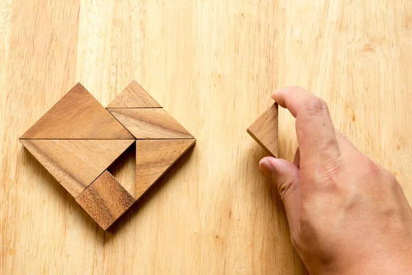 Hombre sostuvo pieza de rompecabezas tangram para cumplir con la forma del corazón en w —  Fotos de Stock