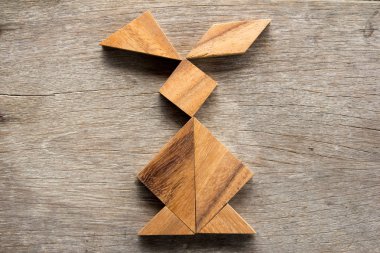 Ahşap arka plan (konsept Paskalya için tavşan şeklinde bulmaca Çince tangram)
