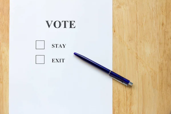 Entscheidungspapier mit Bleibe- und Austrittswahl auf Holz-Hintergrund — Stockfoto