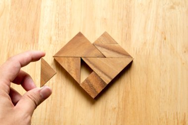 Tangram bulmacanın parçası düzenlenen adam ahşap masa (aşk kavramı üzerinde kalp şekli yerine getirmek için)
