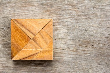 Tangram bulmacanın ahşap arka plan üzerinde kare şeklinde