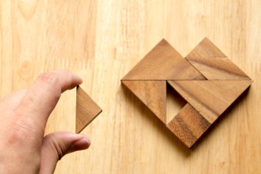 Tangram bulmacanın parçası düzenlenen adam ahşap masa (aşk kavramı üzerinde kalp şekli yerine getirmek için)