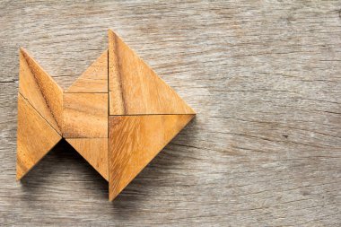 Ahşap arka plan üzerinde balık şeklinde bulmaca Çince tangram