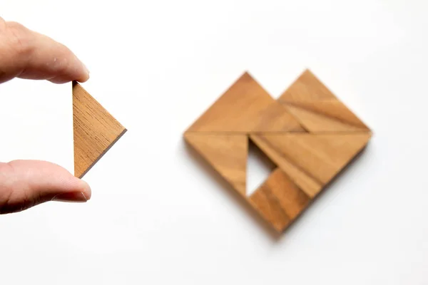 Człowiek się kawałek układanki tangram do spełnienia na białym tle (koncepcja miłości, w kształcie serca) — Zdjęcie stockowe