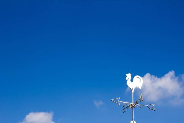 Beyaz horoz weather vane Haritayı mavi gökyüzü arka plan üzerinde rüzgar yönü