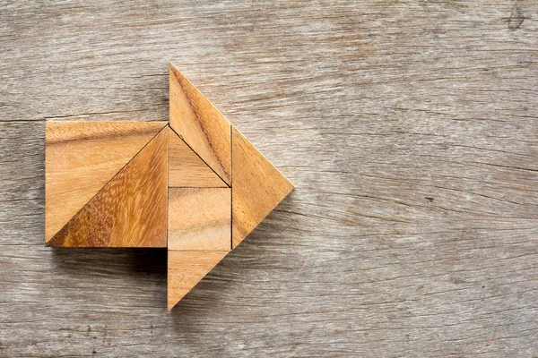Tangram головоломка в форме стрелки на деревянном фоне — стоковое фото