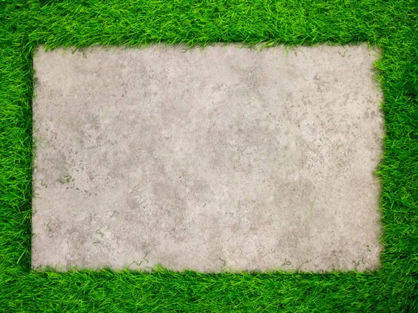 Placa cuadrada de hormigón sobre fondo de césped verde artificial —  Fotos de Stock