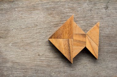 Ahşap arka plan üzerinde balık şeklinde bulmaca Çince tangram
