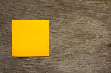 Boş portakal not kağıdı faturası için kahverengi ahşap zemin üzerinde eklemek veya anımsat