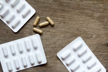 Kahverengi kapsül ve ahşap arka plan (kavramı fo üzerinde beyaz blister