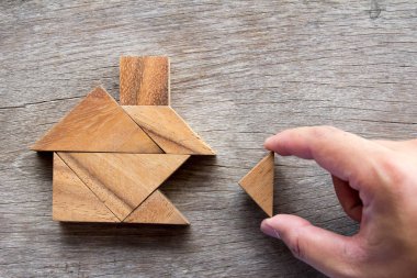Yapı rüya ev veya mutlu yaşam konsepti için ev şekli yerine getirmek için ahşap tangram bulmacanın bekle