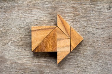 Tangram bulmacanın ahşap arka plan üzerinde ok şeklinde
