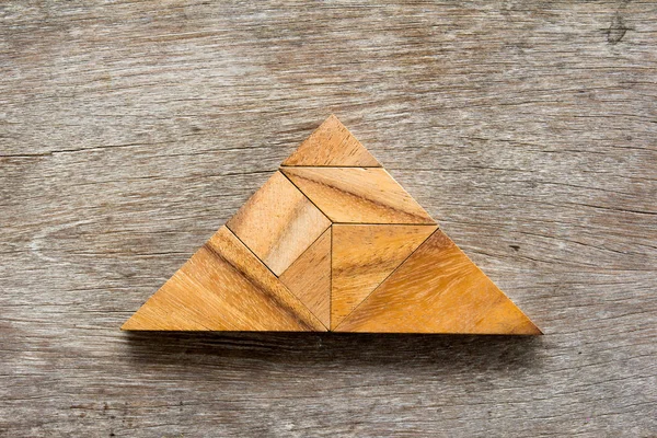 Γρίφος τανγκράμ σε τρίγωνο σχήμα σε φόντο ξύλινη — Φωτογραφία Αρχείου