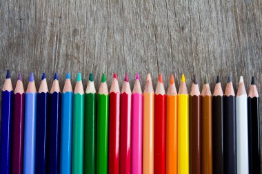 Ahşap arka plan üzerinde renkli kalem satır